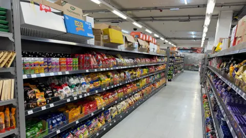 George King/BBC News Row after row of shelves, packed with products