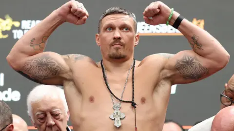 Oleksandr Usyk flexing his biceps
