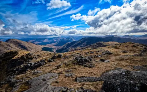 Ian Burchett A mountain range with a blue sky in the background