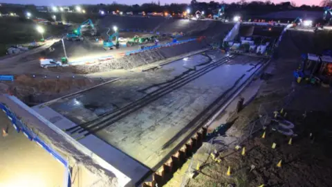 A night-time picture of major engineering works under the M27 motorway.