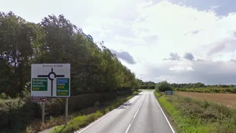 Google The B1249. A roadsign shows the roundabout junction with the A614 is ahead with Bridlington, Carnaby and Nafferton to the left and the M62, Goole and Beverley to the right. It is a sunny day with just patchy clouds in the sky. 