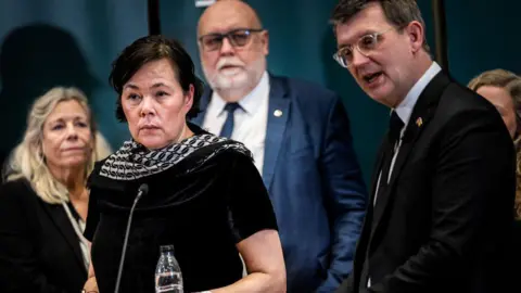 Greenland's Minister for Independence and Foreign Affairs, Vivian Motzfeldt, Denmark's Minister of Defence Troels Lund Poulsen and members of the coalition stand at a podium during a news conference to present a defence agreement on the Arctic and North Atlantic in the Ministry of Defence in Copenhagen, Denmark