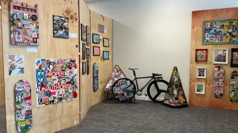 Walls covered with stickers and a bike covered with stickers.