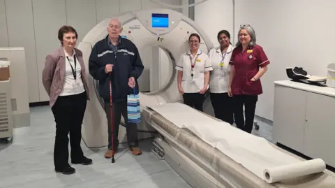 Four medical staff members at the new Woking Diagnostic Community Centre are standing with a patient. 