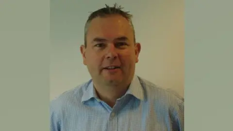 Alan Armstead A head and shoulders shot of Alan Armstead, with short hair and wearing a white and blue patterned shirt