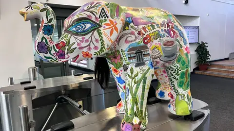 A picture of the colourful elephant, which has many illustrations on it.