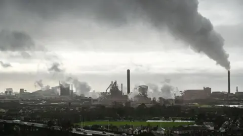 Getty Images The steelworks at Port Talbot before the blast furnace was closed. Steam and smoke rise from tall chimneys and multiple points across the vast complex. The town and the M4 motorway can be seen in the foreground.