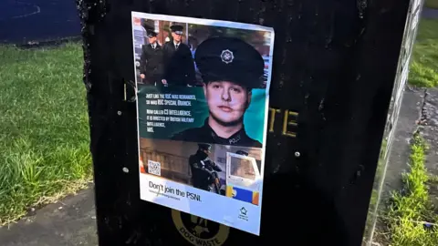 A poster on a structure in Lurgan shows a number of uniformed police officers including one cloe up along with anti-PSNI slogans