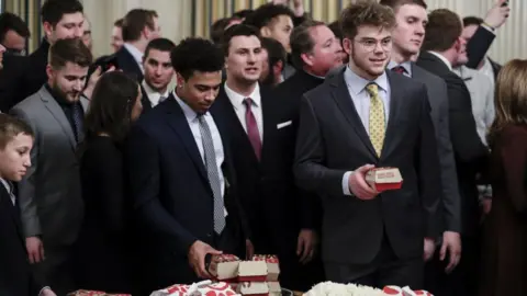 Getty Images 2018 Division 1 Football National Champions, North Dakota State Bison, players take food from a table of McDonald's Corp. Big Mac hamburgers and Chick fil-A Inc. sandwiches as U.S. President Donald Trump, not pictured, welcomes the team at the White House in Washington, DC