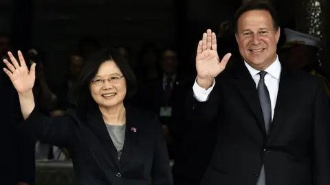 AFP/Getty Images La presidenta de Taiwán, Tsai Ing-wen (i), y el presidente de Panamá, Juan Carlos Varela, saludan a la prensa durante una ceremonia en el palacio presidencial de la ciudad de Panamá, el 27 de junio de 2016.