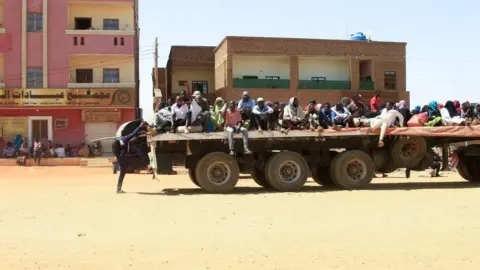 Getty Images People fleeing Khartoum on flatbed trucks