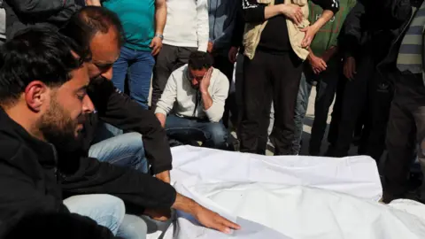 The mourners from Reuters shout on the bodies of the Palestinians covered with Israeli damage, at Al -Quba Al -Shuhada Hospital, in Deir Kalah on March 18, 2025