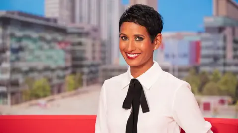 Naga Munchetty posing and smiling in the BBC Breakfast studio