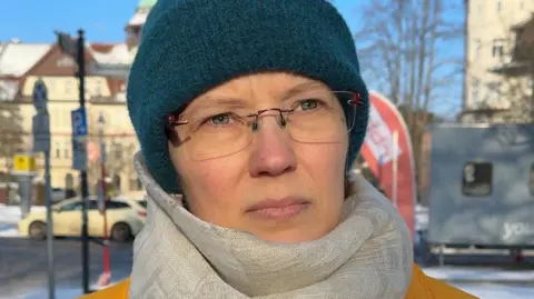 Lena, wearing a scarf and a turquoise hat