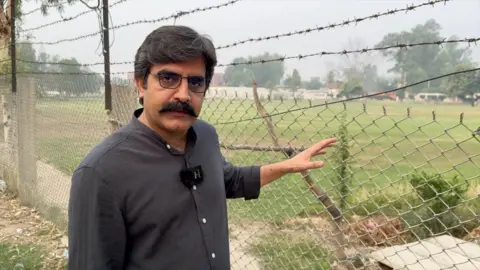 BBC Urdu reporter standing outside a building which was targeted by Indian air strikes on Wednesday