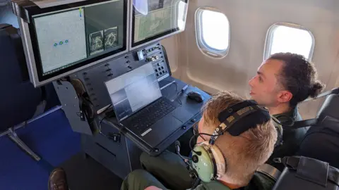 QinetiQ An over the shoulder photograph of inside the test flight with navigation screens visible