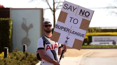 PA Media A Tottenham Hotspur fan holds a placard saying: "No to Super League"