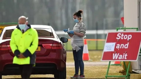 AFP An NHS worker is tested for coronavirus at a drive-through testing centre at Haydock Park racecourse
