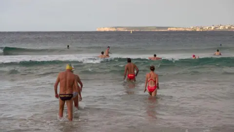 Getty Images Swimmers walking into the water at Bondi beach 