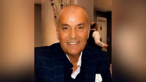 Courtesy Centre for Israel and Jewish Affairs Michel Mizrahi smiles in a casual photograph. He wears a slightly unbuttoned white shirt and a black suit jacket.