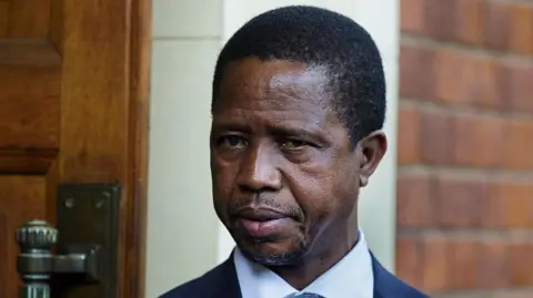 Getty Images A head and shoulders image of Edgar Lungu. His  blue collar and dark jacket can just be seen at the bottom of the picture. 