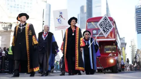 PA Media Others in the procession wore ceremonial robes