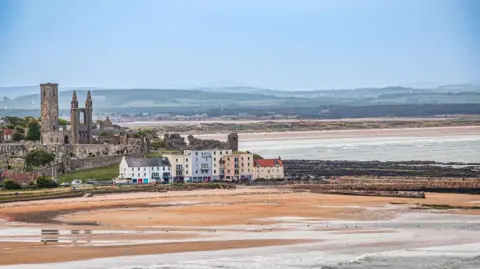 Dennis Clarke A view of St Andrews from a Fife Coastal Path walk from Kingsbarns. The beach  can be seen with colourful houses and the cathedral behind it. Rolling hills can be seen in the distance.