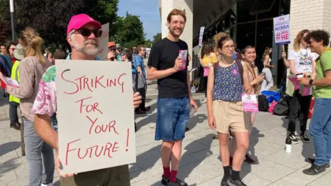 People holding up signs while on strike.