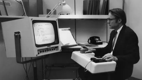 SRI International Ένας νεαρός Bill English κάθεται σε ένα παλιό τερματικό υπολογιστή της δεκαετίας του 1960 σε αυτή τη φωτογραφία αρχείου της δεκαετίας του 1960
