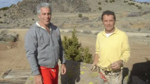 US Department of Justice Jeffrey Epstein in a tracksuit top and Jean-Luc Brunel, with sunsglasses in his hand, pose in an undated photo released by the U Department of Justice