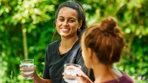 Thames Water In a picture provided by the utility company two women drinking glasses of water outside