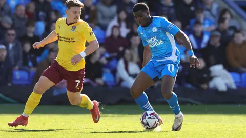Pete Norton/Getty Images Kwame Poku of Peterborough United controls the ball watched by Sam Hoskins of Northampton Town