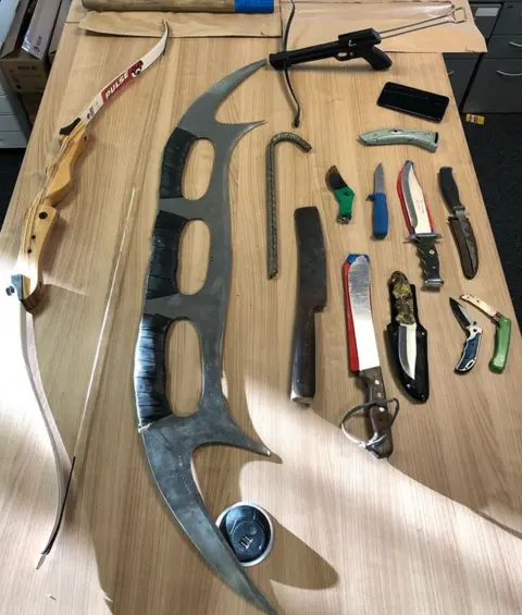 Widnes Police A Klingon bat'leth and other weapons seized from a teenager's bedroom
