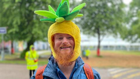 An excited Coldplay fan wearing a pineapple shaped hat