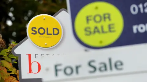 PA Media Two for sale signs outside a house.