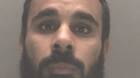 Merseyside Police Abdelmohaimen Mohamed has dark hair and a beard.