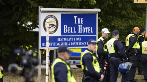 PA Media Police officers ahead of a demonstration outside the former Bell Hotel in Epping