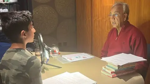 Rudra Sachdev Rudra interviewing an older relative at a desk