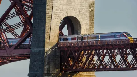 PA Media Hitachi Class 800 train crosses the Forth Bridge in Edinburgh