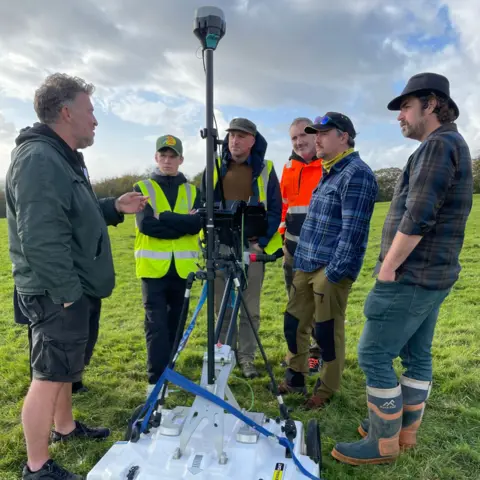 Swansea University The ArchaeoMargam project team meet to discuss their survey work, standing around the ground penetrating radar device 