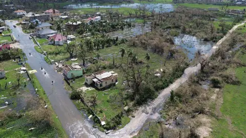 AFP via Getty Images Uma foto aérea de estradas inundadas e pastagens saturadas de água