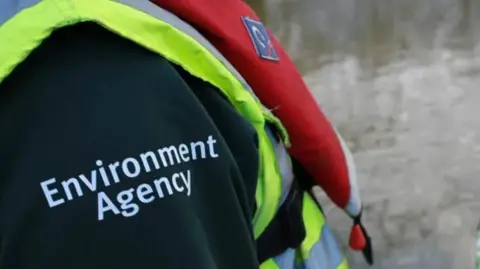Getty Images Words Environment Agency written on worker's sleeve