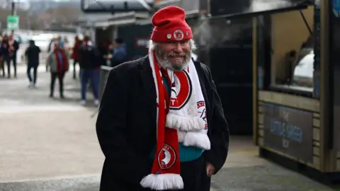 Getty Images A Bristol City fan with a white beard wearing red and white scarf and hat at Ashton Gate