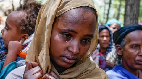 Getty Images An Amhara woman cries at a camp as she recounts experiences of being driven from her home in Oromia - 4 April 2022