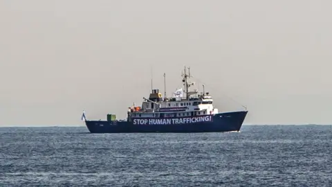 AFP A banner that reads, "Stop Human Trafficking" is attached to the side of the C-Star as it sailed in the Mediterranean Sea