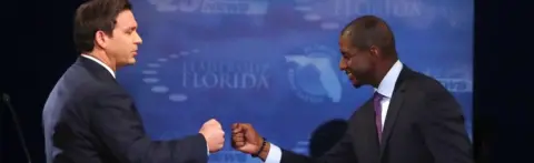 Getty Images Republican Ron DeSantis and Democrat Andrew Gillum fist bump after a debate in Florida