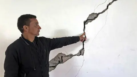 AFP A resident shows a crack on the wall of his house at Joshimath in Chamoli district of India's Uttarakhand state on January 8, 2023