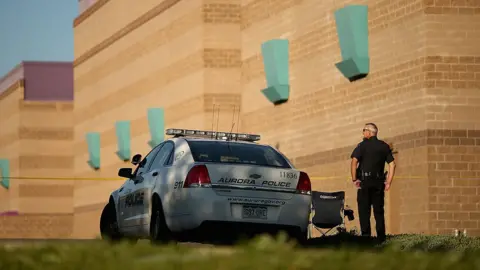 Aurora Police maintains a secure perimeter around the movie theater a day after mass shooting in 2012 in Aurora, Colorado