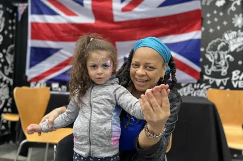 Another little girl gets her face painted with the Union Jack colours