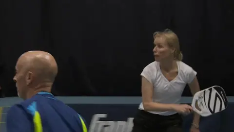 A man and a woman pickleball players in action on the court.